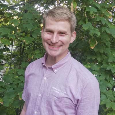 Auf dem Bild ist das Vorstandsmitglied Alex Nolte zu sehen. Er lacht in die Kamera